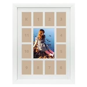 May include: White picture frame with 12 openings for photos. The frame has a collage style layout with a larger opening in the center. The numbers 1 through 11 and the letter K are printed in the openings.