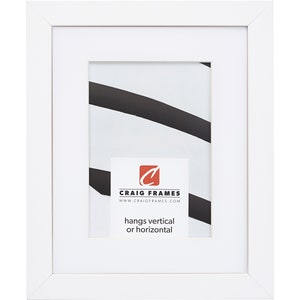 May include: A white picture frame with a white mat. The frame has a rectangular shape and a clean, modern design. The image inside the frame features black and white abstract art. The text "hangs vertical or horizontal" is visible.
