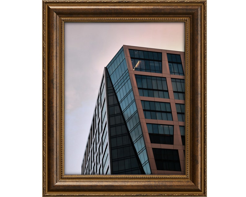 Pu&ograve; includere: Un moderno edificio per uffici con una facciata in vetro e rame contro un cielo nuvoloso.