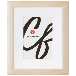 May include: A natural wood picture frame with a white mat and a white background. The frame has a simple design and is made in Michigan. The text "Craig Frames" is printed on the mat.