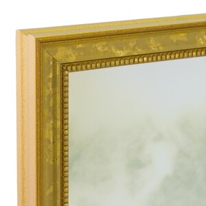 May include: A gold-colored framed mirror with a beaded border. The frame has a distressed finish.
