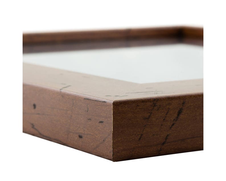 May include: A brown wooden picture frame with a distressed finish. The frame has a simple, rectangular shape and a smooth surface.
