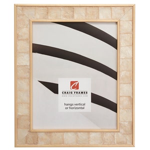 May include: A beige picture frame with a gold inner border and a white mother of pearl outer border. The frame is made of wood and has a matte finish. The frame is designed to hang vertically or horizontally. The text "CRAIG FRAMES" and "www.craigframes.com" is printed on the frame.