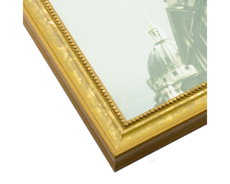 May include: A gold picture frame with a decorative border. The frame is made of wood and has a matte finish.