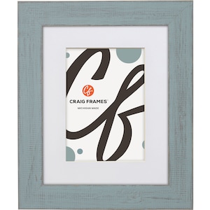May include: A light blue picture frame with a white mat and a white background. The frame has a distressed finish and is made in Michigan. The frame is made by Craig Frames.
