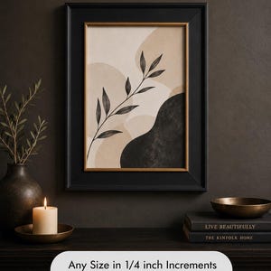 May include: A framed art print featuring an abstract design with beige and black shapes and a black leaf branch. The print is in a black frame with a gold inner border. The text on the image says "Any Size in 1/4 inch Increments up to 30" x 40".