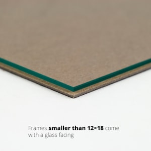 May include: Close-up of the edge of a picture frame showing a brown cardboard backing and a green glass facing. Text reads "Frames smaller than 12x18 come with a glass facing."