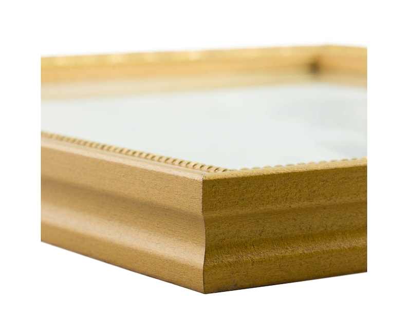 May include: A gold picture frame with a simple, slightly ornate design. The frame has a beveled edge and a slightly raised lip.