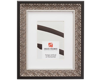 May include: A black and silver picture frame with an ornate design. The frame is made of wood and has a white mat. The frame is 8x10 inches and can be hung vertically or horizontally. The frame is made by Craig Frames.