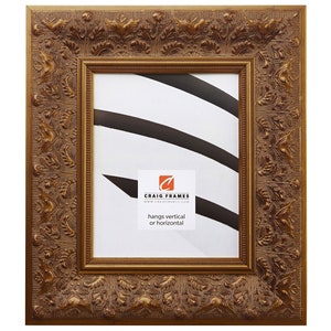 May include: A gold ornate picture frame with a detailed floral design. The frame is made of wood and has a matte finish. The frame is suitable for hanging both vertically and horizontally. The text on the frame reads "Craig Frames" and "www.craigframes.com". The text also reads "hangs vertical or horizontal".
