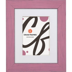 May include: A pink wooden picture frame with a white mount and a white background with the text "CRAIG FRAMES" and "MICHIGAN MADE" in black. The frame has a distressed look.