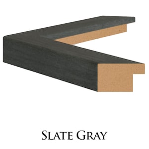 May include: A close-up of a dark grey picture frame with a wood core. The frame is made of a textured material that resembles slate.