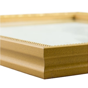 May include: A gold picture frame with a slightly ornate design. The frame is made of wood and has a smooth finish.