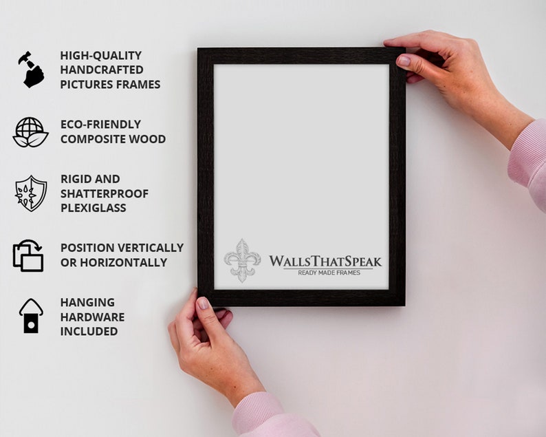 May include: Black picture frame with a white mat and a white background. The frame is hanging on a wall. The frame has a fleur-de-lis design in the bottom right corner and the text "WALLS THAT SPEAK" and "READY MADE FRAMES".