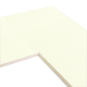 May include: A close-up of the corner of a white mat board with a textured edge.