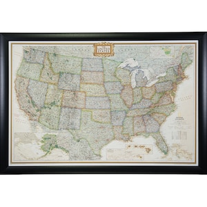 May include: A framed map of the United States with a detailed depiction of the country's geography, including state borders, major cities, and national parks. The map is titled "The United States" and features a gold-colored border. The map is framed in a black frame.