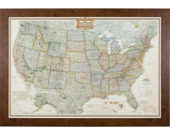 May include: A framed map of the United States with a detailed view of each state. The map is in a brown wooden frame and features the National Geographic logo. The map includes Alaska and Hawaii.
