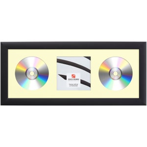 May include: Black rectangular frame with a light yellow matting, designed to hold two CDs and a square photo. The CDs have a reflective, rainbow-colored surface. The square photo space has a white background with black abstract lines.