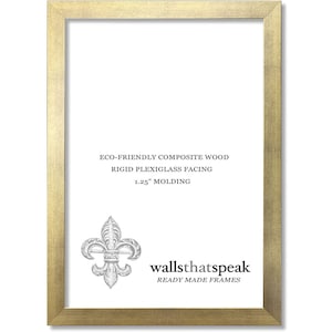 May include: Gold picture frame with a 1.25 inch molding. The frame is made of eco-friendly composite wood with a rigid plexiglass facing. The frame has a fleur-de-lis design in the bottom right corner and the text "wallsthatspeak READY MADE FRAMES".