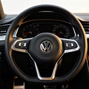 Puede incluir: Un volante de cuero negro con agarres laterales perforados y un logotipo de Volkswagen en el centro. El volante presenta detalles metálicos plateados, botones de control integrados en los radios y un claxon circular en el centro.