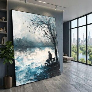 May include: A large rectangular wall art piece featuring an impressionistic painting of a lone figure sitting on a bench under a tree by a body of water. The artwork uses a palette of deep blues, teals, grays, and white, with visible paint drips.