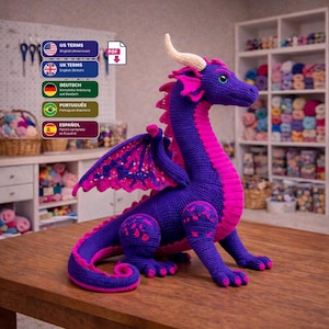Könnte beinhalten: Ein handgefertigter, gehäkelter Drache in Lila und Pink, mit detaillierten Flügeln und Hörnern. Der Drache ist auf einer Holzoberfläche platziert. Das Bild enthält auch Text auf Englisch, Deutsch, Portugiesisch und Spanisch.