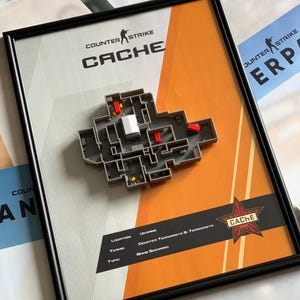 May include: A framed 3D map of the Counter-Strike Cache map, featuring a gray layout with red and blue blocks. The print includes the text Counter-Strike Cache, Location: Ukraine, Teams: Counter-Terrorists & Terrorists, and Type: Bomb Scenario.