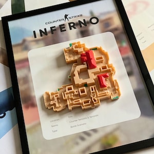 Könnte beinhalten: Gerahmtes Kunstwerk mit der Counter-Strike Inferno-Karte. Die Karte ist ein 3D-Modell in Beige und Rot, vor einem verschwommenen Hintergrund. Der Rahmen ist schwarz, und der Text "COUNTER STRIKE INFERNO" ist sichtbar. Zusätzlicher Text enthält "Italien", "Counter Terrorists & Terrorists" und "Bomb Scenario".