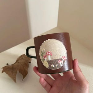 Peut inclure: Ensemble de trois tasses en céramique avec une finition mate et mouchetée. Chaque tasse présente une couleur différente : bleu clair, crème et gris. Les tasses ont un design simple et moderne avec une anse confortable.