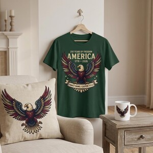 May include: A dark green short-sleeve t-shirt featuring a graphic of a bald eagle with red, white, and blue wings. The text reads 250 YEARS OF FREEDOM AMERICA 1776-2026 and FAMILY NAME / CUSTOM TITLE. A matching pillow and mug are also displayed.