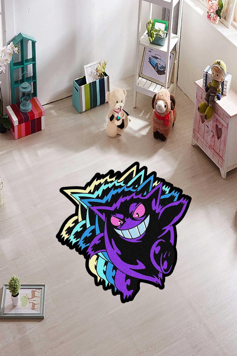 May include: A purple and black rug featuring a cartoon character with a wide grin and spiky edges. The rug has a colorful design with shades of purple, blue, and yellow. The rug is placed on a light-colored wooden floor.
