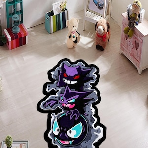 May include: A colorful, cartoon-style rug featuring three stacked ghost characters in shades of purple, black, and blue. The rug has a black border and a gray, smoky background. This decorative rug is suitable for a child's bedroom or playroom.