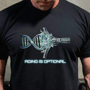 以下が含まれることがあります： 黒いTシャツ。DNAストランド、ジッパー、および「Peptide」とラベルされたバイアルを特徴とするグラフィックデザイン。テキスト「AGING IS OPTIONAL」は未来的なフォントで表示されます。デザインは青、緑、銀を使用しています。