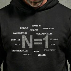May include: Black hooded sweatshirt with the text "N=1" in large, gray letters, surrounded by various scientific terms in white. The sweatshirt is a dark color, and the text is clearly visible.