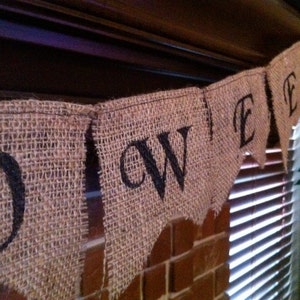 This is a burlap banner that says halloween. The burlap is a natural color with hand painted letters in black. The font is super fun with fun accents on each letter.
