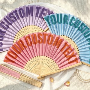 Abanicos de colores personalizados con tipografía retro curva: Añade cualquier texto, nombre o cita. Ideales para negocios, bodas o eventos.