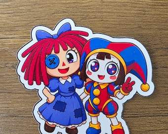 Geweldige, op een digitaal circus geïnspireerde, glanzende sticker met Ragatha en Pomni | Verkrijgbaar in 2 maten