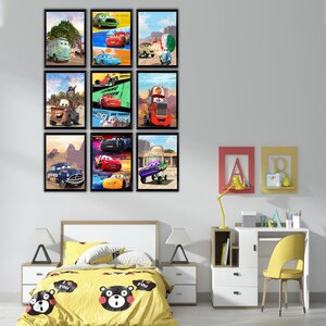 Puede incluir: Una colecci&oacute;n de nueve l&aacute;minas de arte mural rectangulares y enmarcadas que presentan varios personajes de coches animados de la franquicia Cars, dispuestas en una cuadr&iacute;cula de tres por tres en una pared lisa sobre una cama con edred&oacute;n amarillo.