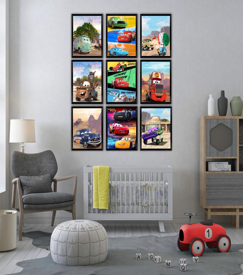 Puede incluir: Un conjunto de pared de galer&iacute;a con nueve p&oacute;steres rectangulares enmarcados que presentan varios personajes de coches animados de la pel&iacute;cula Cars, dispuestos en una cuadr&iacute;cula de tres por tres sobre una pared gris claro y una cuna blanca.