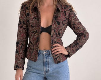 May include: A long-sleeved, zip-up jacket featuring a black base with an intricate, multi-coloured paisley pattern in shades of deep red, gold, and muted green. The jacket has a structured collar, a full-length front zip, and a fitted silhouette.