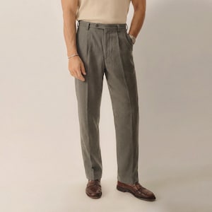 May include: Gray trousers featuring a high-waisted design with a single button closure, belt loops, and a pleated front. These full-length pants have a straight-leg cut and are paired with brown leather loafers, creating a clean and structured look.
