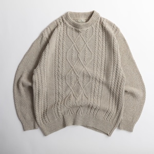 May include: A beige cable-knit sweater with a crew neck. The sweater features a central diamond pattern and textured knit panels. The sleeves and upper chest have a textured pattern. The L.L.Bean label is visible on the back of the neck.