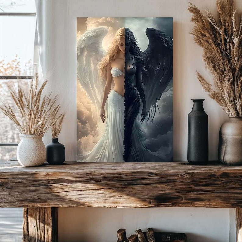 May include: A rectangular wall art print depicting a split figure with a light side featuring a blonde person with white wings and a white dress, and a dark side featuring a dark-skinned person with black wings and a black dress against clouds.