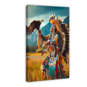 May include: A canvas wall art print depicting a figure wearing a large, colorful feathered headdress and intricate, multi-colored traditional clothing with fringe, holding a bald eagle on one arm in a grassy field with mountains in the distance.