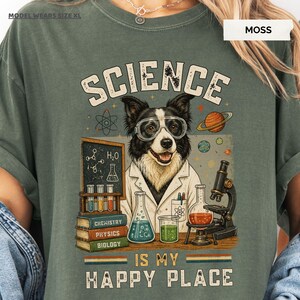 Könnte beinhalten: Ein moosgrünes T-Shirt mit einer Grafik eines Hundes, der eine Schutzbrille und einen Laborkittel trägt. Das Design zeigt eine Tafel mit chemischen Formeln, ein Mikroskop, Reagenzgläser, Bücher mit der Aufschrift Chemistry, Physics, Biology und den Text SCIENCE IS MY HAPPY PLACE.
