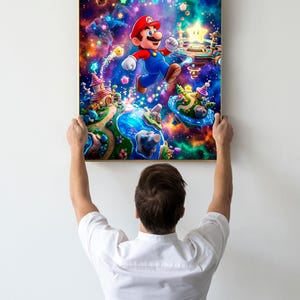 May include: A framed print depicting Mario, the video game character, in a colourful, fantastical scene. The artwork shows Mario mid-jump, surrounded by stars, floating islands, and whimsical structures. The print is held up by a person.