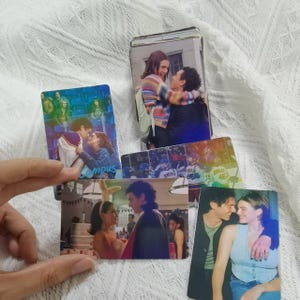 Op de afbeelding: Een verzameling rechthoekige fotokaarten met diverse scènes van koppels en groepen. De afbeeldingen tonen individuen in verschillende settings, waaronder een persoon met konijnenoren, een gestreepte trui en mensen in vrijetijdskleding.