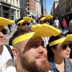 May include: A group of people wearing yellow headbands with a cloud-like design. The headbands are bright yellow and stand out against the background of a city street. The people are wearing sunglasses and casual clothing.