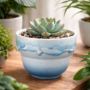 May include: A set of three ceramic mugs with a speckled, matte finish. The mugs are in shades of cream, light gray, and dark gray. Each mug has a simple, minimalist design, perfect for coffee or tea.