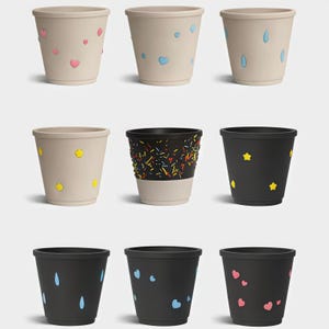 May include: A collection of nine decorative flower pots in various colors and designs. Some pots are beige with heart, raindrop, and star accents. Others are black with yellow stars, blue hearts, and raindrops. One pot has a black top with colorful sprinkles.
